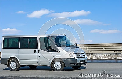 Silver van on road with blue horizon Stock Photo