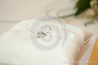 Silver Wedding rings on a white silk pillow Stock Photo