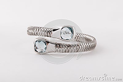 Silver womens bracelet with two light blue diamonds in shape of two square on white background. Stock Photo
