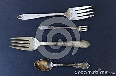 Weathered silverware of forks and spoons against black background Stock Photo