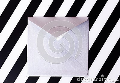 Silvery paper envelope on striped black and white background Stock Photo