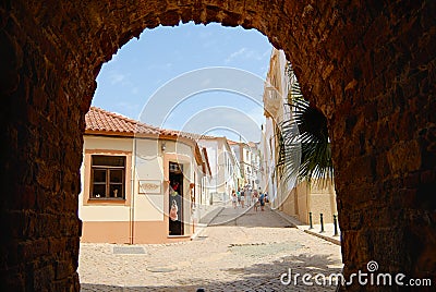 View to the street with historical buildings trough an arch in Silves, Portugal. Editorial Stock Photo
