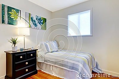 Simple bedroom with black nightstand and painting. Stock Photo