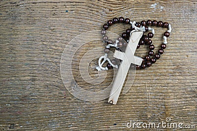 Simple Catholic rosary and cross on rustic wood Stock Photo