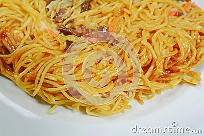 Simple chicken chow mien meal on a white plate and on a wooden table. Stock Photo