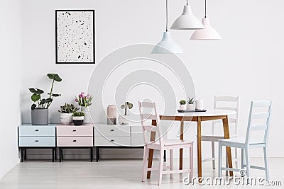 Simple dining room interior with a table, chairs, lamps, poster Stock Photo