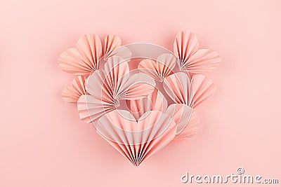 Simple elegant pink paper heart of flying little ribbed hearts on cute pink color - Valentine day background, top view, copy space Stock Photo