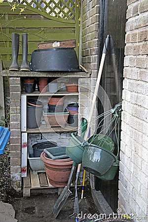 Simple garden shelves with pots and gumboots, ready for lock-down Stock Photo