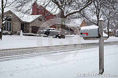 Home Mailbox along a Snow Covered Neighborhood Street with Homes during a Snowfall in Suburban Illinois Editorial Stock Photo