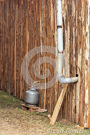 Installation of gas canister outside humble wood and chimney for smoke outlet Stock Photo