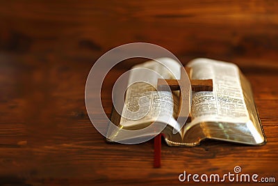 a simple light oak colored cross on a open bible . Stock Photo