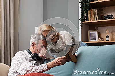 Simple living. Elderly retired couple enjoying their retirement, reminiscing entertaining in their warm home. Senior people Stock Photo