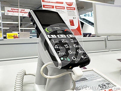 Simple mobile phone with large buttons on display stand in electronics store Editorial Stock Photo