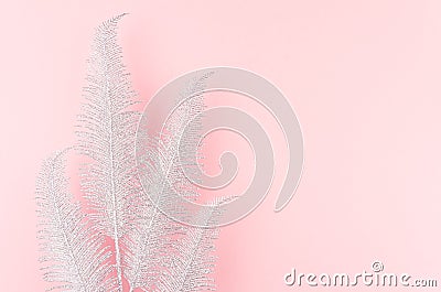 Simple modern bright festive background - sparkle silver palm branch as border on pastel pink backdrop. Stock Photo