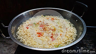 Simple noodle soup with the addition of tomatoes and cabbage. Typical noodles from Indonesia. Selective focus. Stock Photo