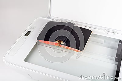 Simple scanner, photo copier, office copying machine scanning a small old vintage book laying on the glass surface, digitalization Stock Photo