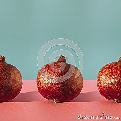 Simple square composition with row of pomegranates on two coloured background Stock Photo