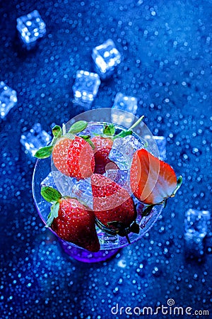 Simple still life. sliced strawberries in a vase on a blue background Stock Photo