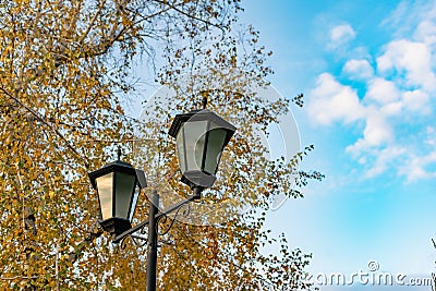 Simple street lights under the open sky. Black metal frame and dusty white glass Stock Photo