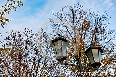 Simple street lights under the open sky. Black metal frame and dusty white glass Stock Photo