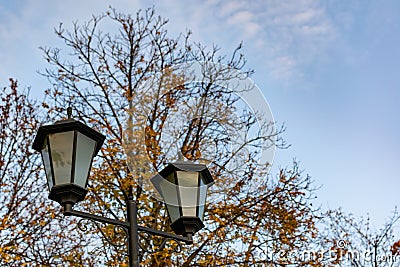 Simple street lights under the open sky. Black metal frame and dusty white glass Stock Photo