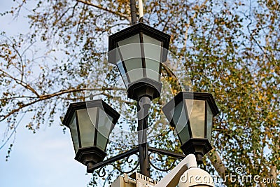 Simple street lights under the open sky. Black metal frame and dusty white glass Stock Photo