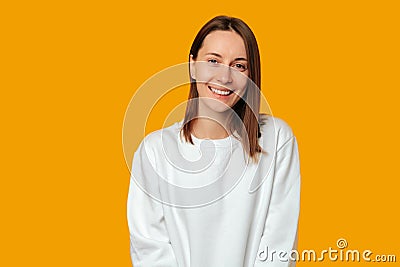 Simple studio portrait of a young modern woman who is smiling at the camera. Stock Photo