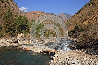 Simple timber bridge and Langtang Khola, river in Nepal. Stock Photo
