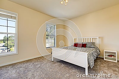 Simple upstairs bedroom with soft peach walls, gray carpet Stock Photo