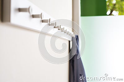 Simple white wall coat hanger with a hanging shirt Stock Photo