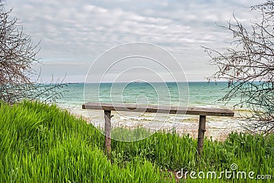 A simple wooden bench on the beach. Stock Photo