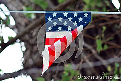 Simplified flag with American colors with red stripes and white stars on blue background hangingfrom line Stock Photo