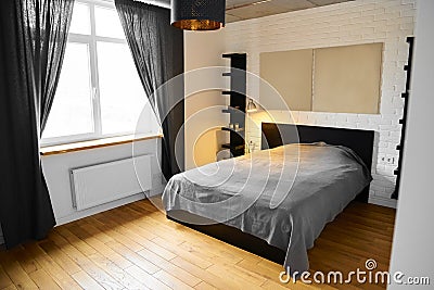 Simply bedroom in industrial design with white brick wall, wood floor, concrete ceiling, black cotton curtains and Stock Photo