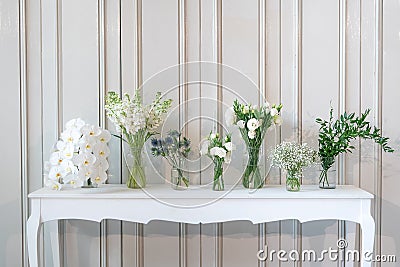 Simply composition of different white flower in vase on white vintage table Stock Photo