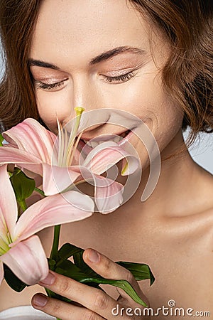 Positive delighted girl smelling her favorite flowers Stock Photo