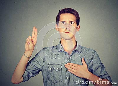 Sincere man swearing with hand on heart Stock Photo
