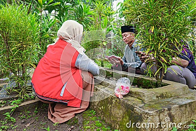 A mother and father and one son are reading the holy Koran to pray for someone who has died Editorial Stock Photo