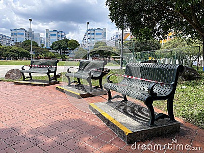 COVID-19. Social safe distancing rules in public spaces during coronavirus outbreak. Public seats park benches are sealed off with Editorial Stock Photo