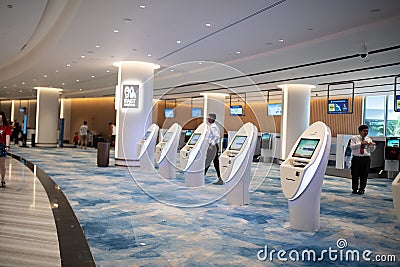 SINGAPORE - June, 2019: a traveller at the self check-in kiosk at Terminal 4, Singapore Changi Airport. Changi Airport is a major Editorial Stock Photo