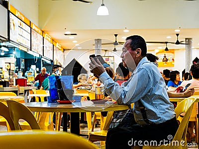 SINGAPORE - 17 MAR 2019 - A middle aged man in office atire enjoys a late night beer at an eatery / coffeeshop / kopitiam, / Editorial Stock Photo