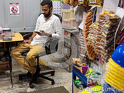 SINGAPORE - 16 MAR 2019 â€“ A Singaporean Indian male shopkeeper in a traditional corner store / provision shop / minimart Editorial Stock Photo