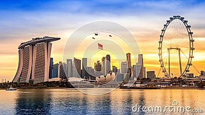 Singapore National Day helicopter hanging Singapore flag flying over the city Stock Photo