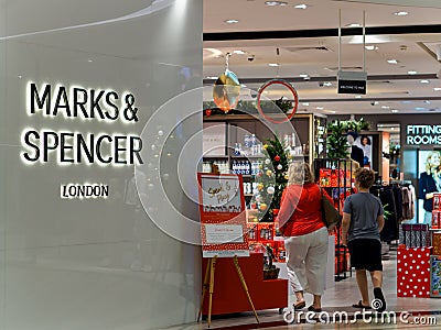 SINGAPORE - 17 NOV 2019 - White Caucasian shoppers enter a Marks & Spencer store Editorial Stock Photo
