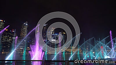 CLOSE UP: Colorful lasers lighting up the sky at nighttime in Singapore city. Editorial Stock Photo