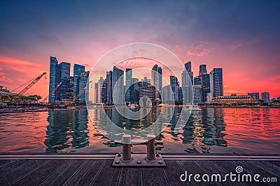 Singapore Skyline and view of business district downtown with wooden walkway on Marina Bay at sunset. Stock Photo