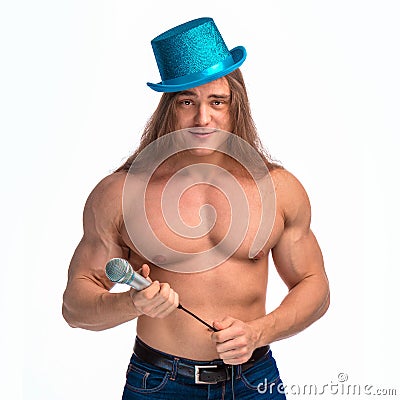 Singer bodybuilder shirtless with long hair in a blue hat with a microphone Stock Photo