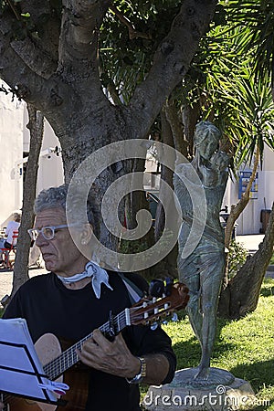 Singer of Neapolitan songs in public performance in front of a statue of mother with child Editorial Stock Photo