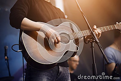 The singer plays a guitar of dark color Stock Photo