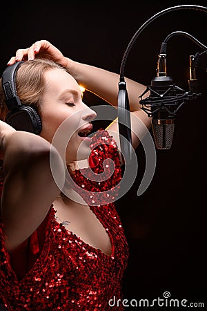 Singer or radio host blogger working in a professional studio. Recording a soundtrack, album, working with a label. Vertical photo Stock Photo