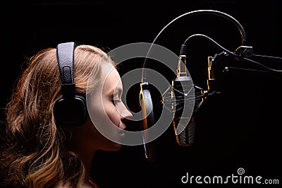 A singer or radio host is working in a recording studio with a microphone in headphones close-up, blogging, radio, recording an Stock Photo